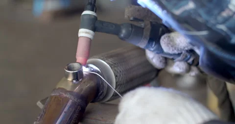 Technician is welding pipe to add position of o2 sensor.Car pipe welding. Stock Footage 316591836