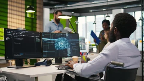 Technician in wheelchair using AI on computer to optimize performance Stock Footage 313017263