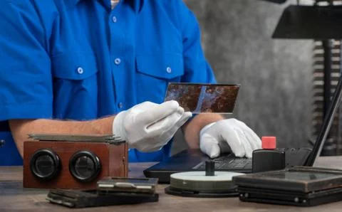 Technician with white gloves digitizing old photography on glass plate Stock Photos