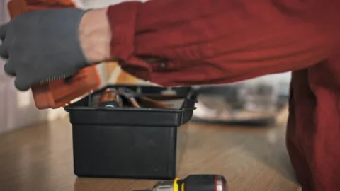 A technician in work clothes and gloves prepares to perform a home repair. H Stock Footage 340786671