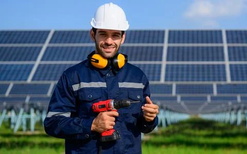 Technician worker installing solar panels at solar cell farm Stock Photos