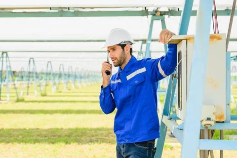 Technician worker installing solar panels at solar cell farm Stock Photos