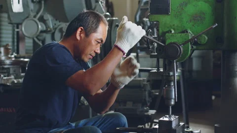 Technician worker using drilling machine for metalworking in workshop factory Stock Footage 204054698