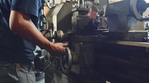Technician worker using turning lathe machine for metalworking in factory Stock Footage 204054008