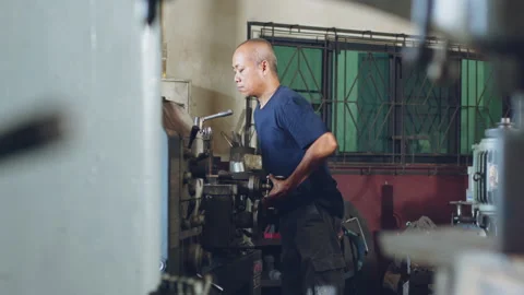 Technician worker using turning lathe machine for metalworking in factory Stock Footage 204054037
