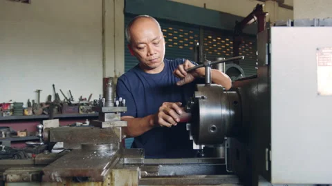 Technician worker using turning lathe machine for metalworking in factory Stock Footage 204054155