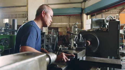 Technician worker using turning lathe machine for metalworking in factory Stock Footage 204054231
