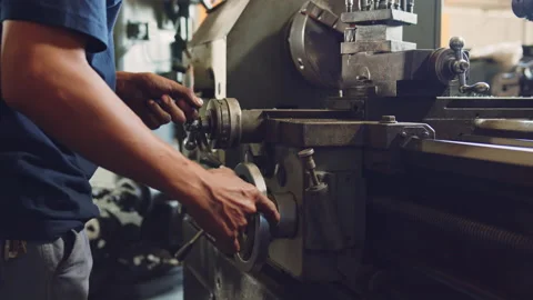 Technician worker using turning lathe machine for metalworking in factory Stock Footage 204054262