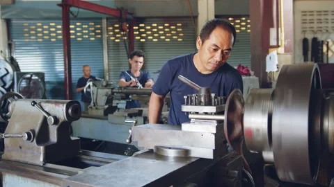 Technician worker using turning lathe machine for metalworking in factory Stock Footage 204054663