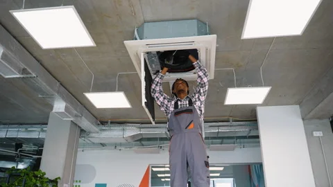 Technician working on ceiling air conditioning system Stock Footage 309483675