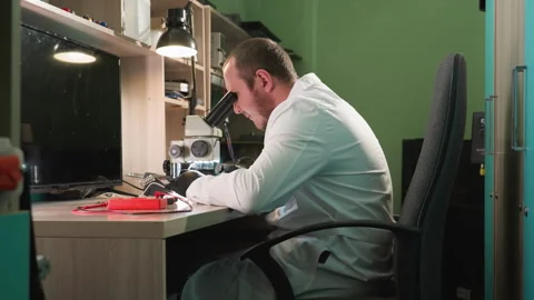 Technician Working on Circuit Board Under Microscope in Tech Lab Stock Footage 281374060