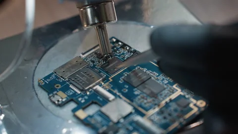 Technician Working on Circuit Board Under Microscope - Close-Up View Stock Footage 284360017