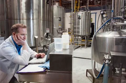A technician working on a computer in a bottling plant Stock Photos