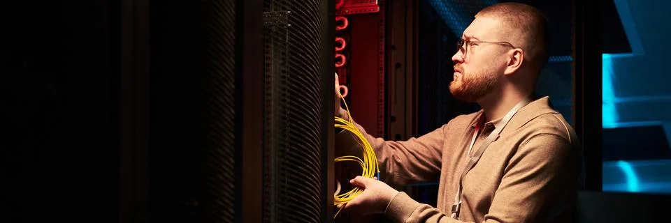 Technician Working in Data Center Fixing Network Cables Stock Photos
