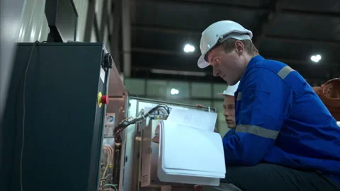 Technician working on the electrical control cabinet of robotic arm Stock Footage 262757089