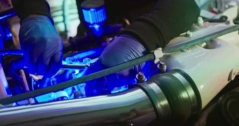 Technician Working on Engine with Blue Lighting 스톡 동영상 323743100