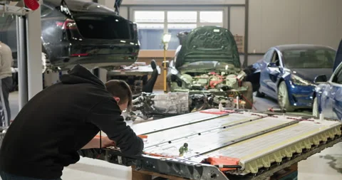 Technician Working On EV Battery In Car Repair Shop Stock Footage 277327295