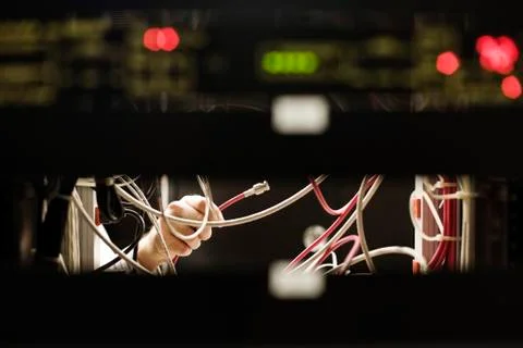 Technician working on main racks of servers in a computer server room. Stock Photos