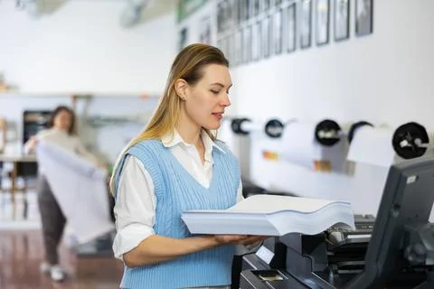 Technician working on plotter and cutter machine in printing shop Stock Photos