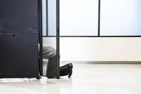 A technician working in the rack area of a computer server farm. Stock Photos