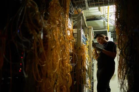 Technician Working in Server Room with Cables and Networking Equipment Stock Photos