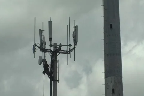 Technician working on top of cellular antenna tower 1 Stock Footage 773018