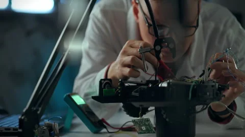 A technician works on drone assembly and repairs in a workshop during daylig Stock Footage 289577348