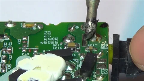 Technician works with solder using a soldering iron on a printed circuit board. Stock Footage 115500740