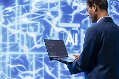 Technician writing code for AI applications development on notebook 스톡 사진