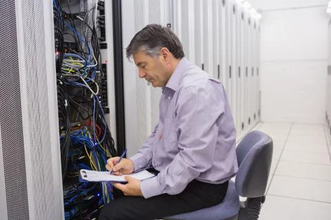 Technician writing notes on the servers Stock Photos
