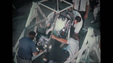 Technicians adjusting spacecraft couch into test stand Stock Footage