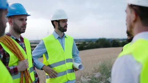 Technicians and engineers talking by wind turbines farm Stock Footage 281661517