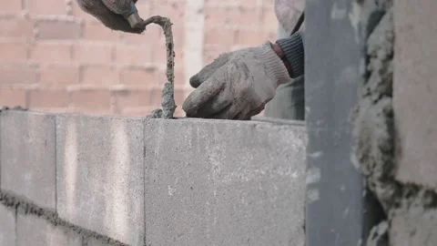 Technicians are building walls made of brick blocks by hand, stacking them one b Stock Footage 148669833