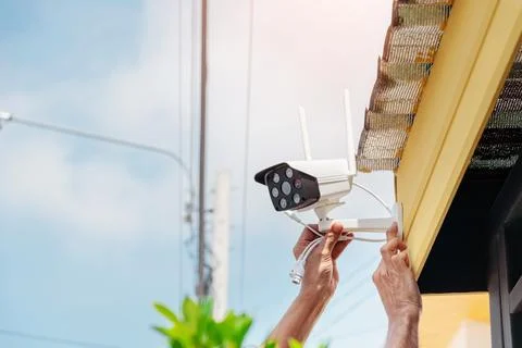 Technicians are installing a wireless CCTV camera. Stock Photos