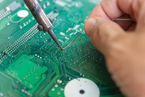 Technicians are using a soldering iron for repairing electronic Photos
