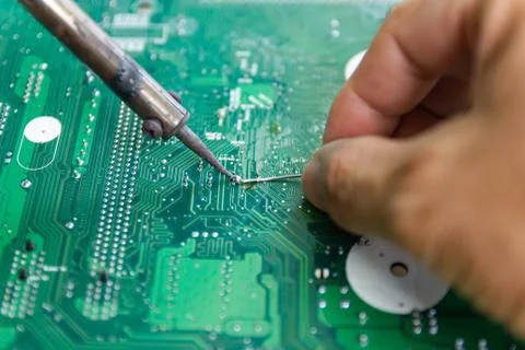 Technicians are using a soldering iron for repairing electronic Photos