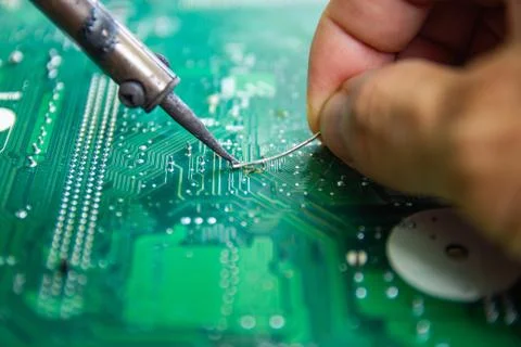 Technicians are using a soldering iron for repairing electronic Photos