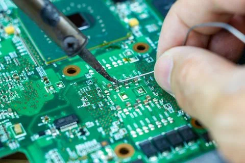 Technicians are using a soldering iron for repairing electronic Photos