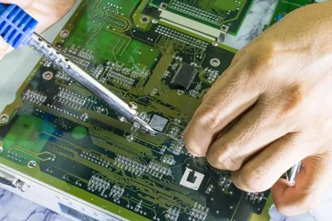 Technicians are using a soldering iron for repairing electronic Photos