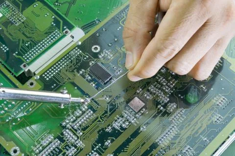 Technicians are using a soldering iron for repairing electronic Photos