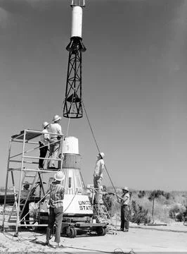 Technicians attach the escape tower to the Mercury capsule prior to assembl.. Stock Photos