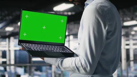 Technicians in data center analyzing performance outputs on green screen laptop Stock Photos