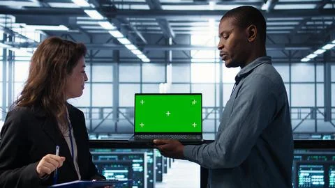Technicians in data center using green screen mockup laptop Foto stock