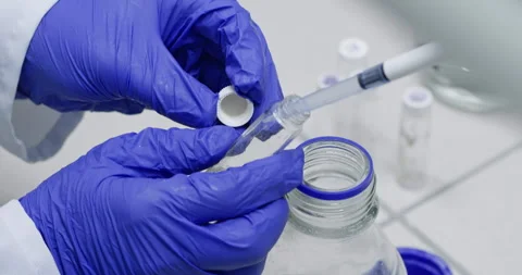 Technicians drip water with pipette into flask in laboratory Stockbeeldmateriaal 274394013
