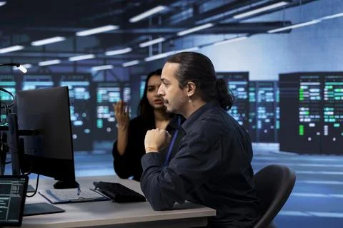 Technicians ensuring data center hardware operates efficiently, doing checkup 스톡 사진