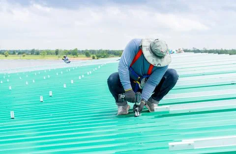 Technicians fitting leg support solar cell panel on roof Stock Photos