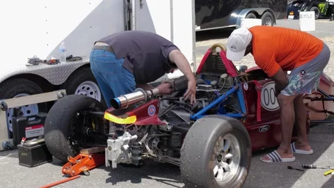 Technicians fixing Formula One race car. 库存影片 157789629