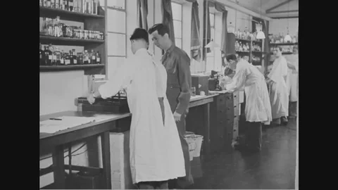 Technicians at general hospital look under microscope to study the bacteria 1918 Stock Footage 83830894