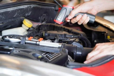Technician's hand holds a digital thermometer, which measures the heat of t.. Stock Photos