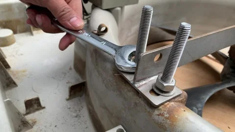Technician's hand loosening a nut on a threaded rod using a spanner Stock Footage 346360225